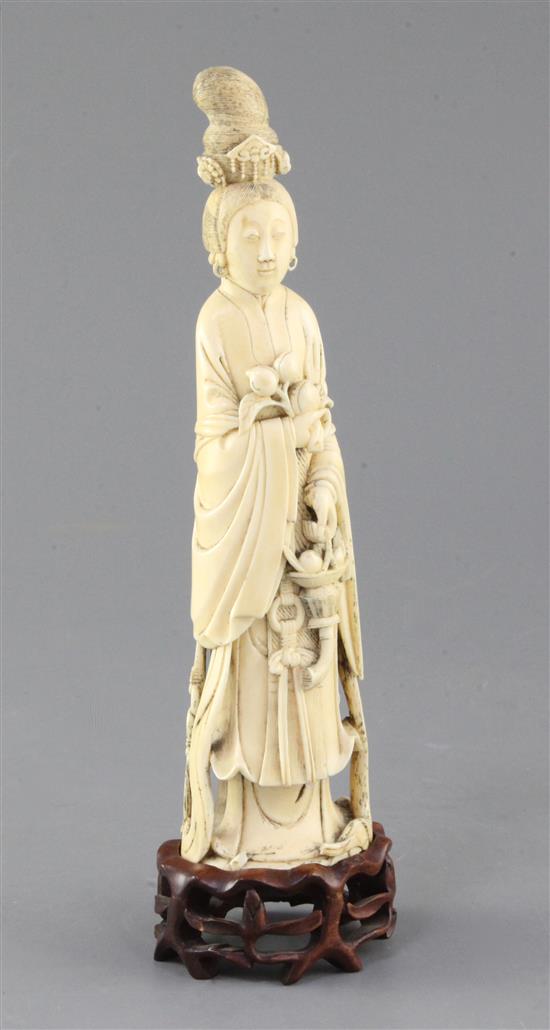 A Chinese ivory standing figure of He Xiangu, late 19th / early 20th century, 22.3cm, wood stand